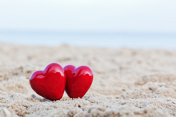 Two red hearts on the beach symbolizing love, Valentine's Day, r