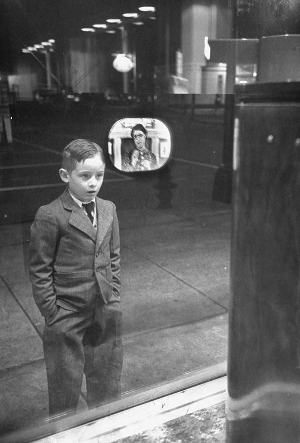 Niño ve la televisión a través del escaparate de la tienda (1948).